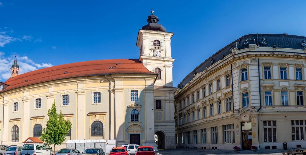 Holy Trinity Church (left) and the Sibiu City Hall (right)